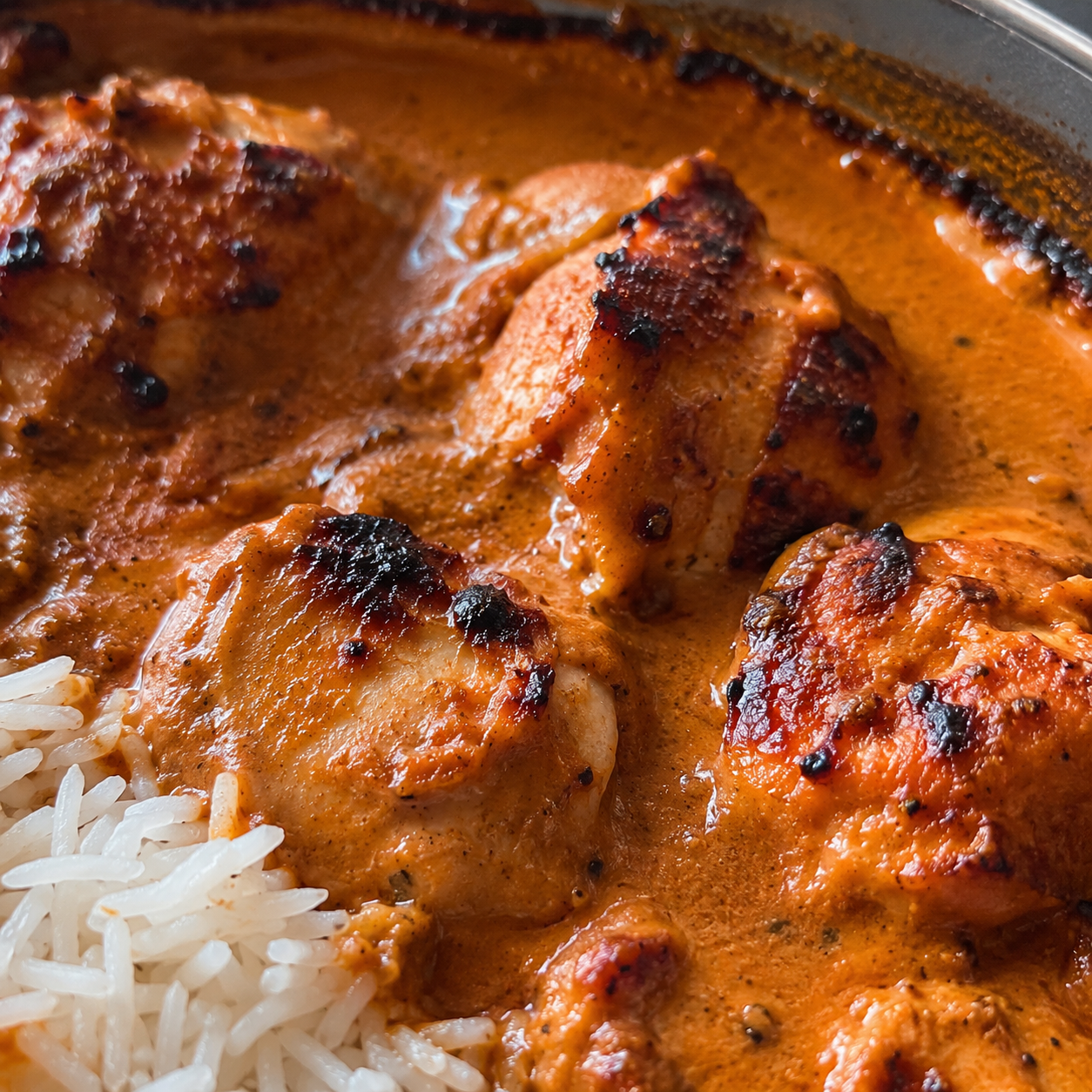Nahaufnahme von zartem Butter Chicken in cremiger orange-roter Tomatensoße